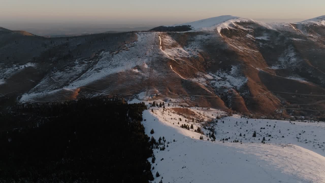 Snow-covered peaks at sunrise, tranquil mountain scene, golden light.
