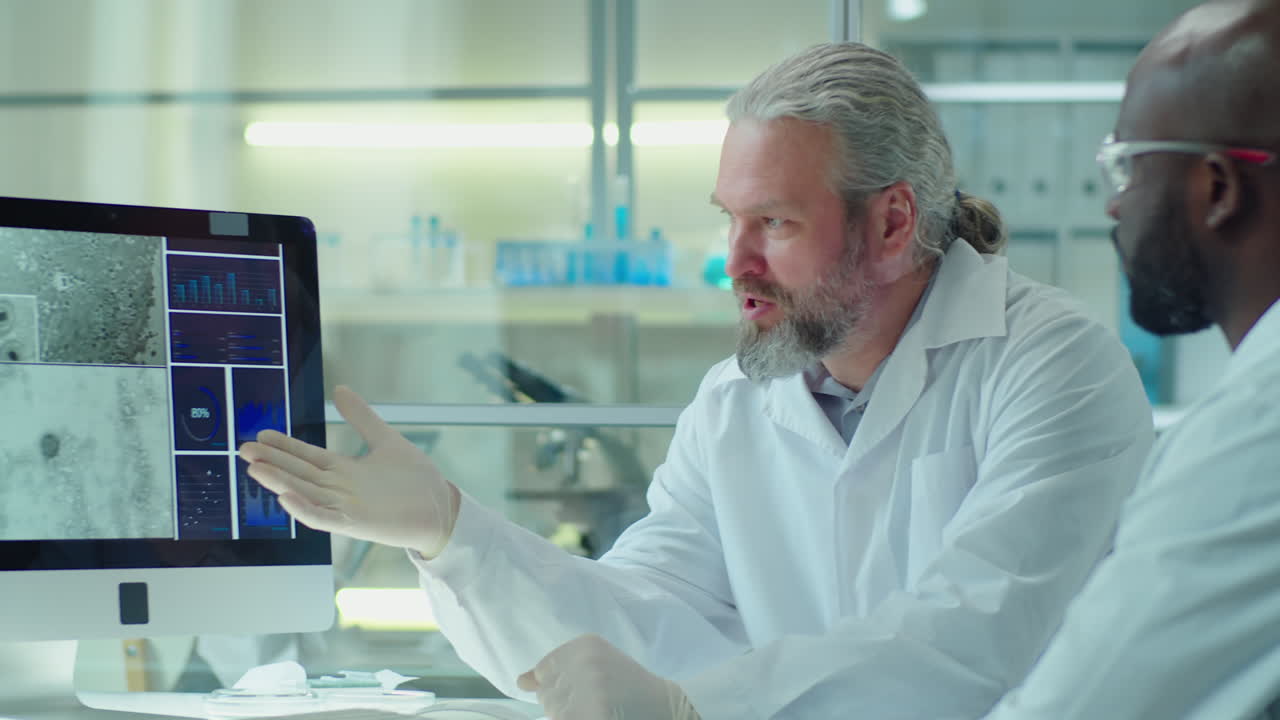 Professional Scientists Discussing Microscopic Image on Computer Display