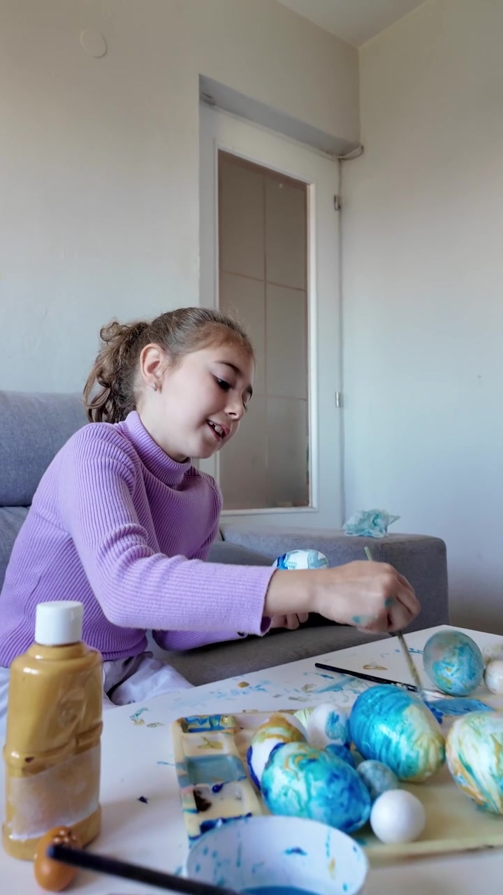 Girl decorating Easter eggs at home