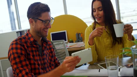 ejecutivos discutiendo sobre tableta digital en la oficina