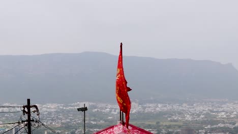 bandera sagrada del templo de la diosa hindú ondeando con el fondo de la montaña brumosa