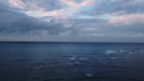 dramatic pink clouds over calm ocean waves, sunrise, waikiki, hawaii, aerial, slow-motion