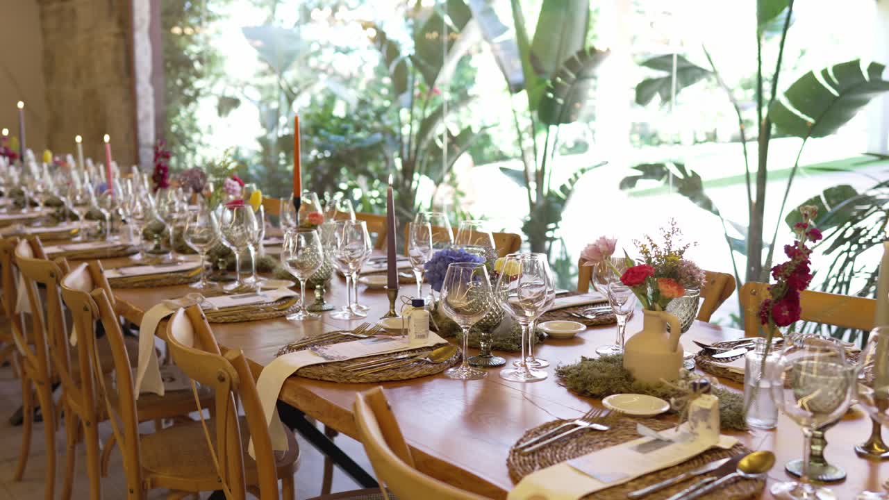 decorated wedding reception table with glassware candles flowers and natural light