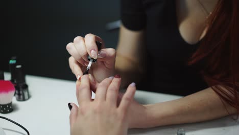 manicurist applies nail varnish by different colors in a beauty salon. woman getting nail manicure, spa treatments.