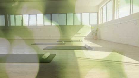 yoga mats and rolled towels in studio with green bokeh animation