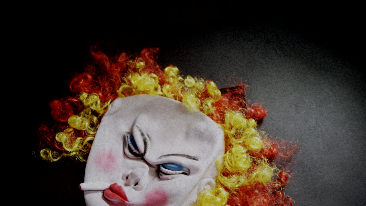 máscara de payaso aterrador cayendo sobre una superficie gris contra un fondo parpadeante