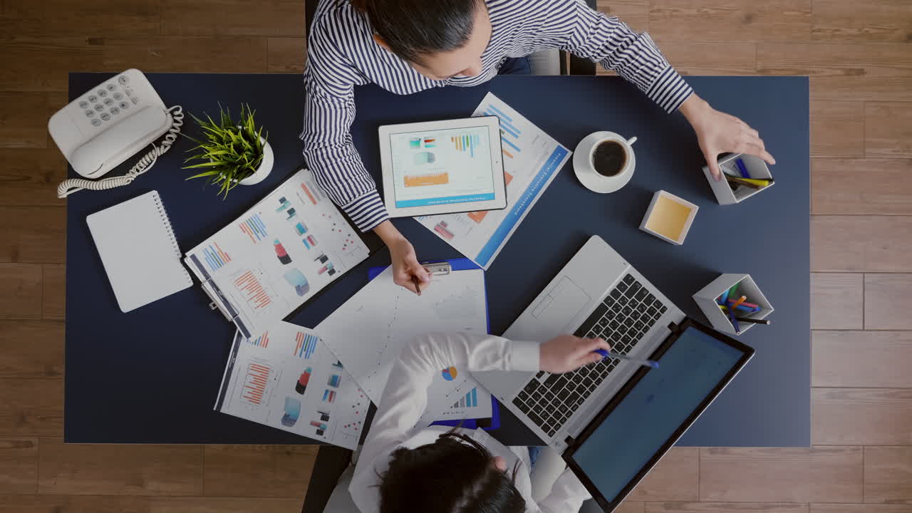Top view of managers women discussing financial accounting paperwork
