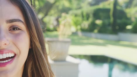 portrait of happy biracial woman with sunglasses in garden on sunny day