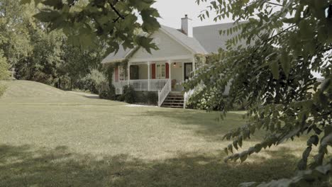 elegant slow motion reveal from behind a tree of a beautiful backyard of a white house at the strathmere resort and spa in ottawa, canada