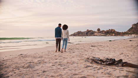 Walking,-couple-and-holding-hands-on-the-beach