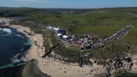 tomada con avión no tripulado del famoso campeonato de surf margaret river pro 2023 en australia occidental durante un día soleado: personas descansando en una playa de arena frente al océano