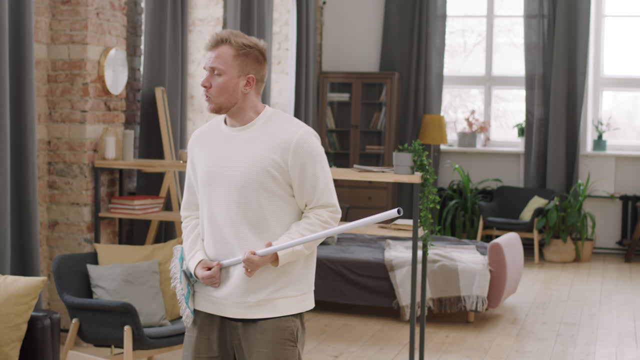 Young Man Pretending to Play Music on Mop