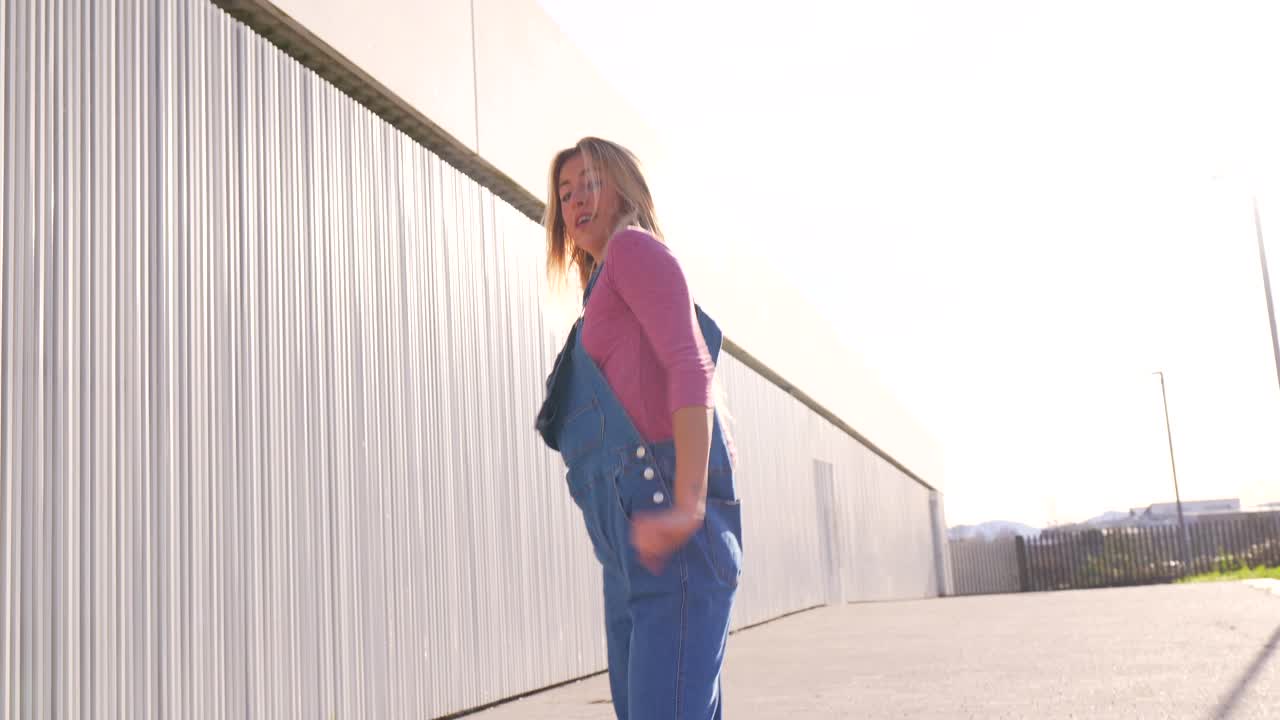 Young woman in denim overalls outdoors