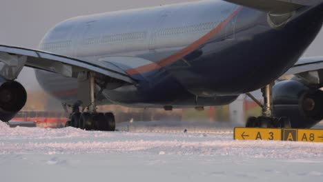 avión de pasajeros en una pista de aterrizaje nevada