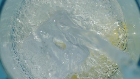 pure water flowing into a glass with ice and lemon accent