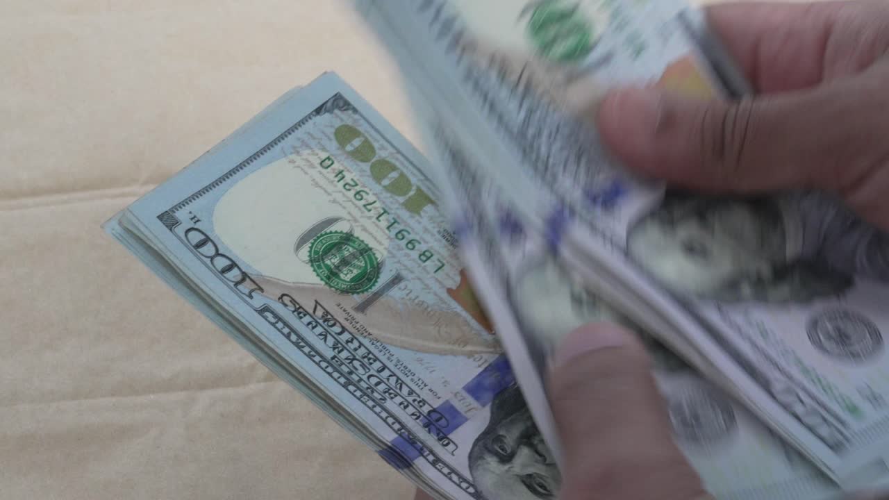 Nærbillede af hænder, der holder og tæller en stak amerikanske hundredekronesedler, koncept for kontant finansiel transaktion, 4K video