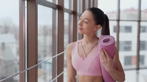 Beautiful-girl-with-yoga-mat-goes-to-workout