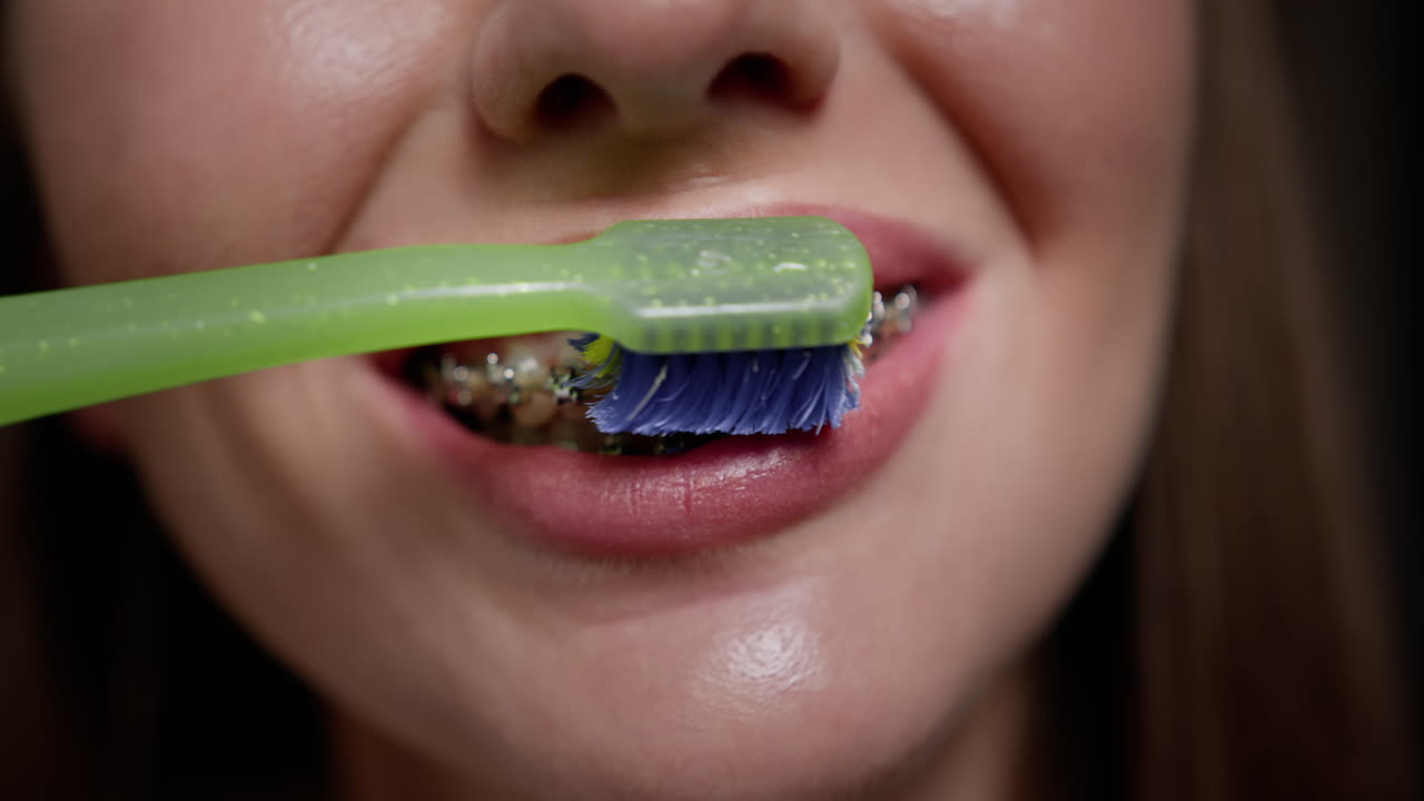 mujer cepillándose los dientes con aparatos dentales