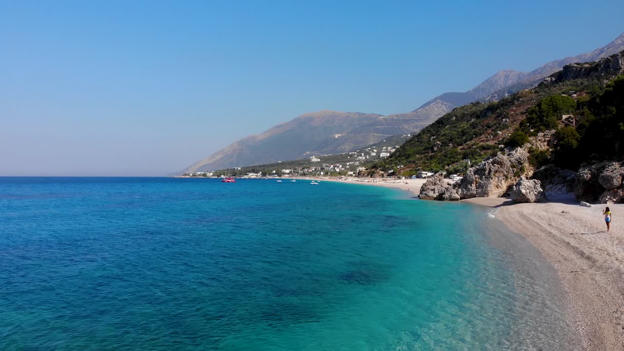 Paradise beach with pebbles washed by crystal azure sea water on beautiful coastline of Albania