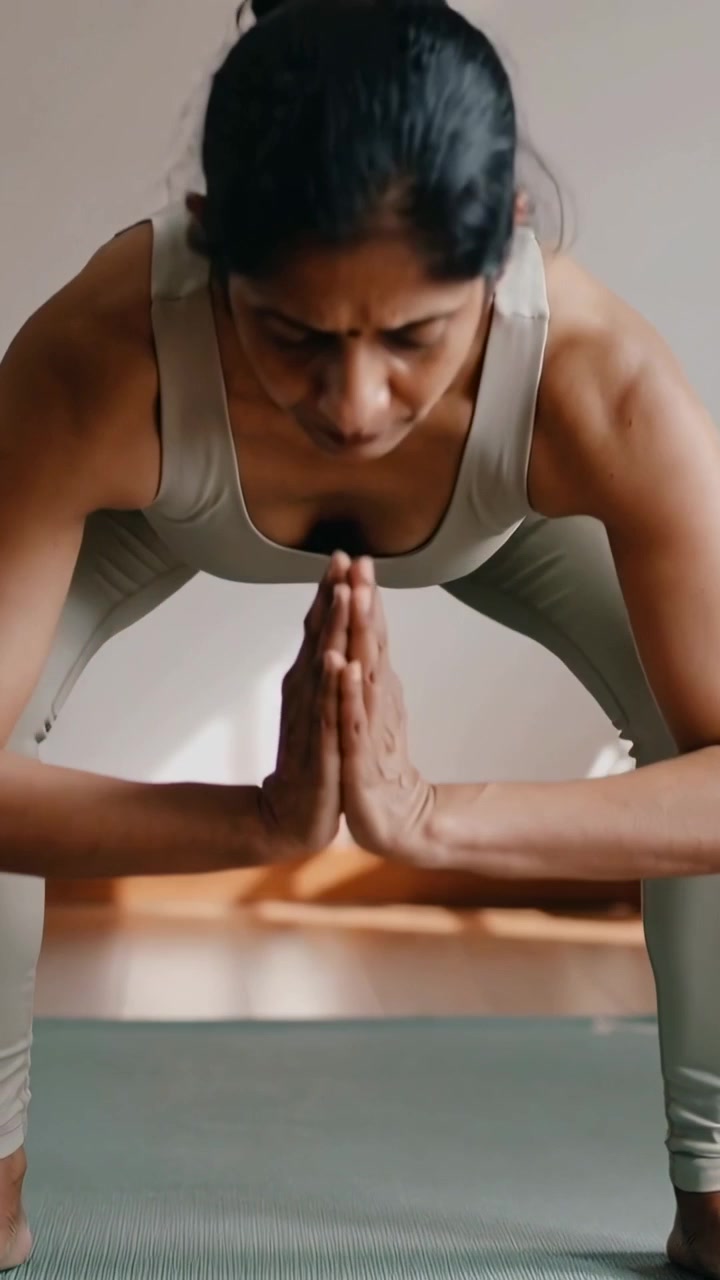 Video verticale: Donna in abbigliamento sportivo che si solleva dagli avambracci in uno squat su un tappetino da yoga a casa, tonificando le gambe