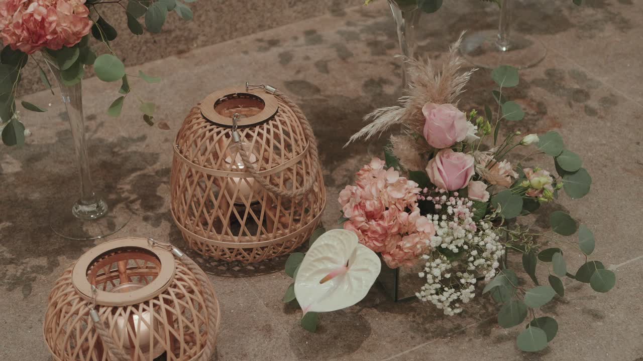 Elegant mix of pastel flowers and wicker lanterns creating soft romantic wedding decor