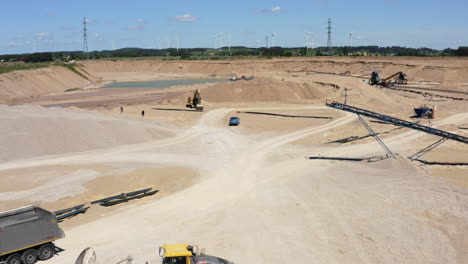 aggregate materials extraction at open-pit mine - rocks, sand, and gravel transported by conveyor belt system. - aerial shot