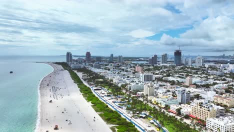 Eine-Wunderbare-Drohnenaufnahme-Aus-Der-Luft-Von-Einem-Sandstrand-In-Miami,-USA,-Eine-Vorwärtsaufnahme,-Die-Eine-Faszinierende-Meereslandschaft-Einfängt,-Die-Menschen-Sogar-Bei-Wolken-Genießen