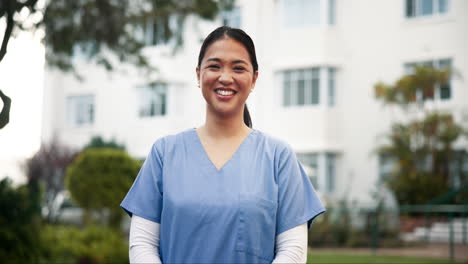 portrait of a smiling asian nurse in uniform outdoors