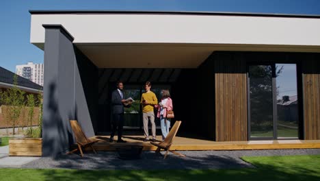 real estate agent showing modern house to a couple