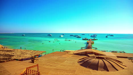 looking over a red sea resort beach with yachts anchored in the turquoise water - time lapse