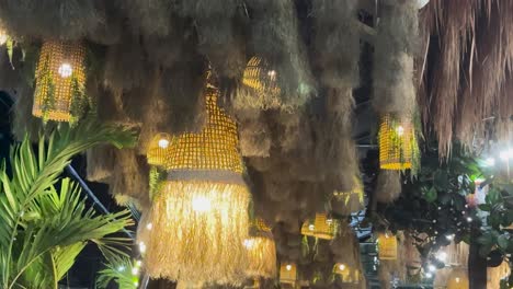 golden lanterns glow warmly amidst tropical foliage in a serene outdoor restaurant setting at night in phuket, thailand