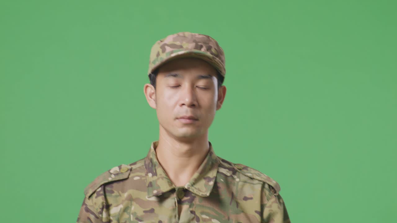 녹색 스크린 배경 스튜디오에서 걸어가는 아시아 남자 군인의 클로즈업