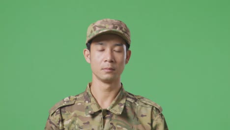 primer plano del hombre asiático soldado caminando en la pantalla verde estudio de fondo