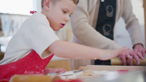 man cuts out baking paper and arranges them on a baking sheet