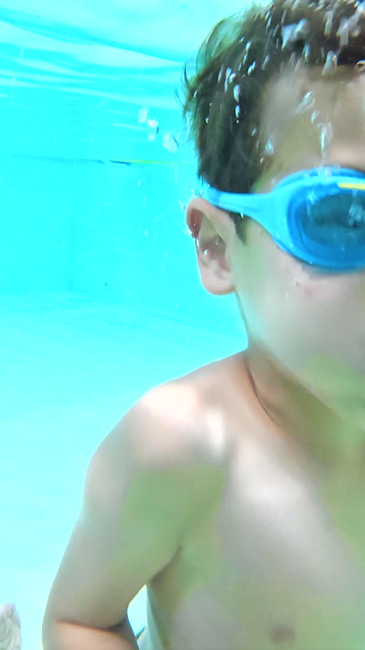Boy swimming underwater with bubbles