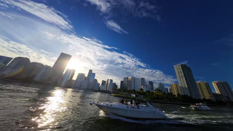 girls having a party, dancing on the moving yacht. skyline of american metropolis at backdrop. fpv drone footage.