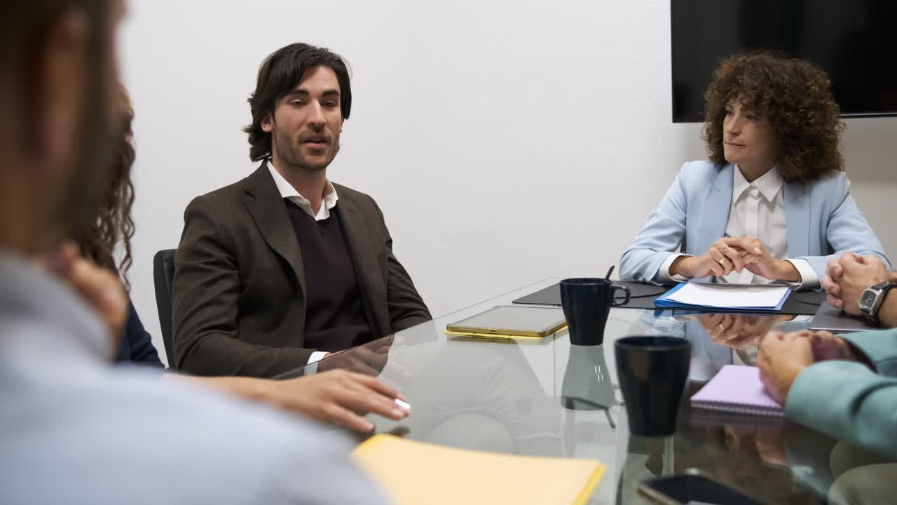 Confident businessman discussing strategy with colleagues during meeting