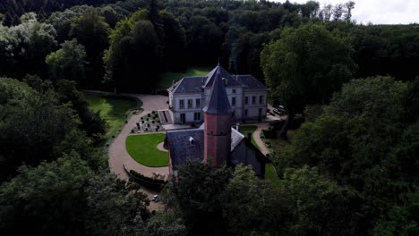 Un-Magnífico-Castillo-Renovado-En-Medio-De-Su-Bosque,-Con-Su-Fuente-Y-Capilla