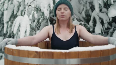 caucasian woman during the winter bath in tube outdoors.