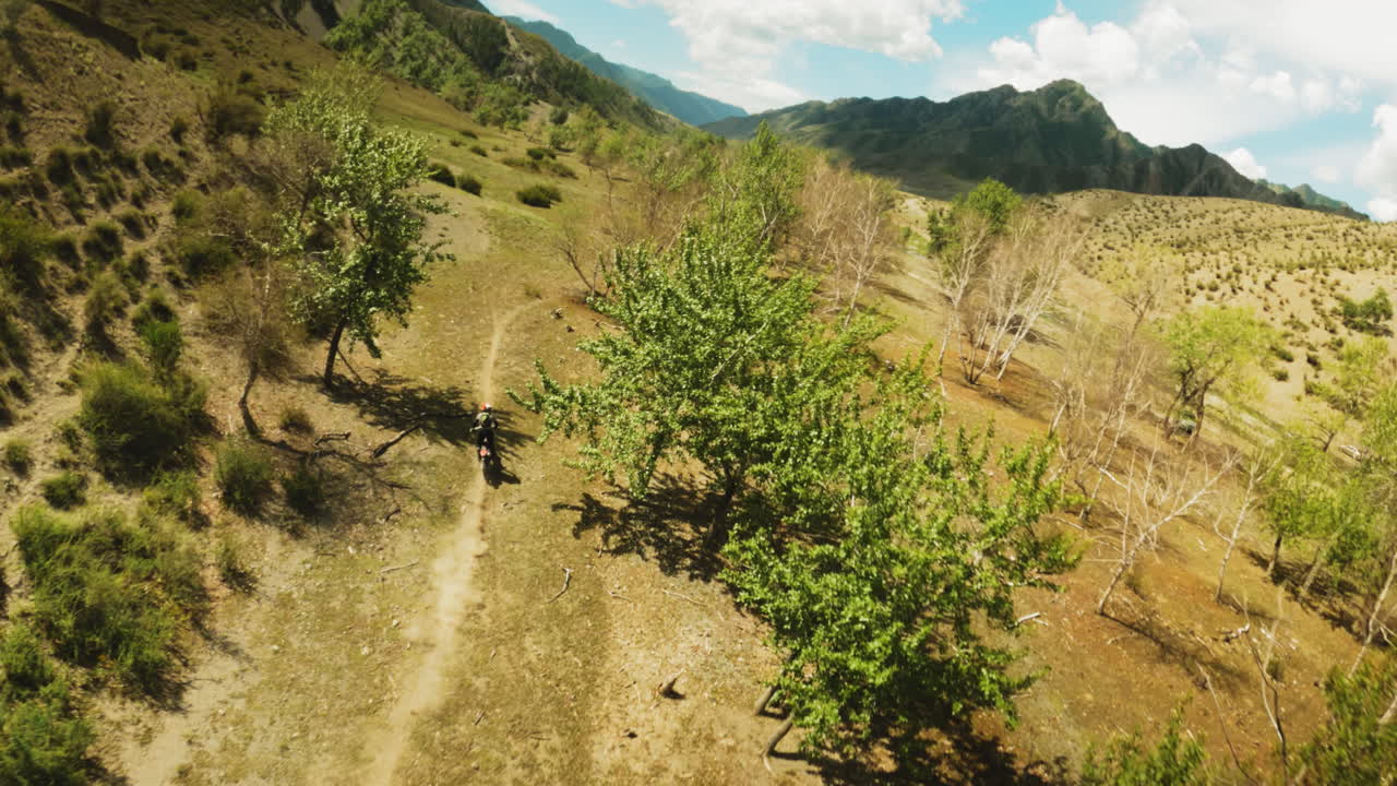 motociclista viaja en motocicleta a través de las tierras altas fpv. deportista disfruta de motocicleta extrema en la naturaleza salvaje en un día soleado desafío de ruta de motocross