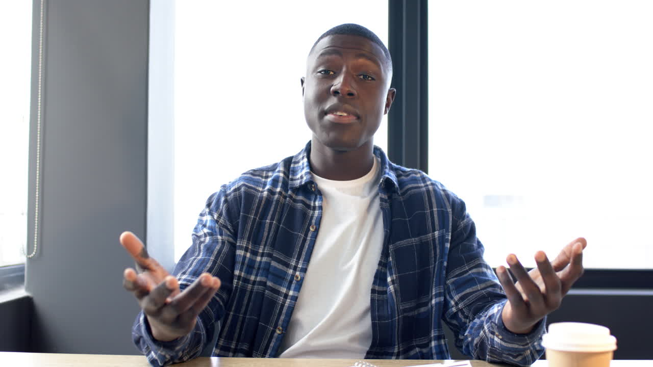 Portrait of african american businessman on video call in office, slow motion, copy space