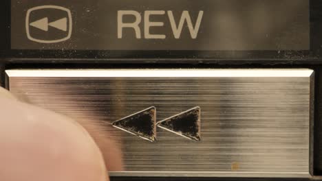 extreme close up of buttons on an old antique or vintage vcr pushing the rewind button