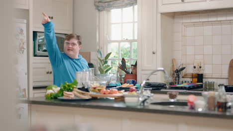 un adolescente feliz con síndrome de down bailando en la cocina divirtiéndose celebrando un baile divertido disfrutando del fin de semana en casa
