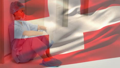 switzerland flag waving against stressed caucasian female health worker at hospital