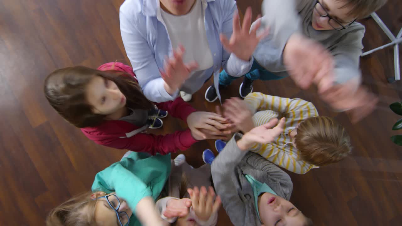 seis adolescentes y el maestro unidos de manos