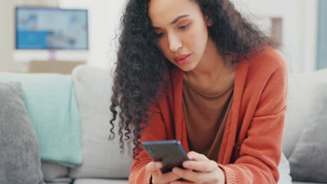 Woman,-phone-texting-and-reading-on-sofa-in-home