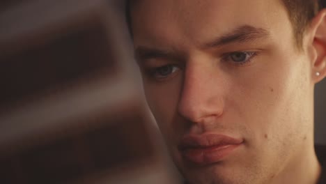 Face-Of-A-Man-Looking-At-Film-Negatives-In-Blurred-Foreground