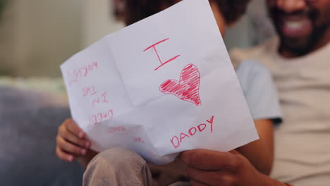 child giving handmade card to father