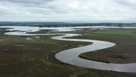 aerial over winding river, lake and grass wetlands