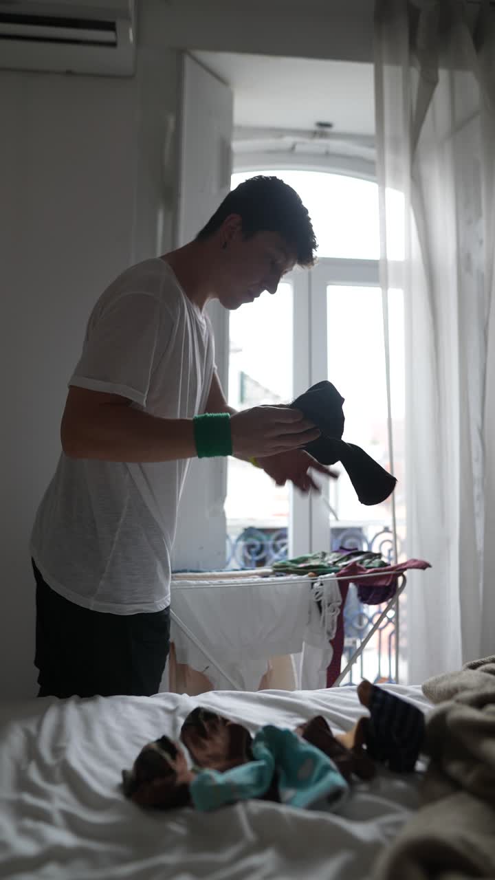 Man doing laundry in bedroom